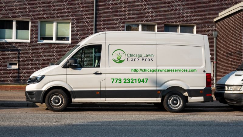 Van: Two white vans in front of a building, with one featuring contact details and brand name located in Chicago, IL.