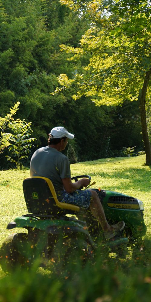 A man riding a lawn mower through a field, showcasing a lawn care service based in Chicago, IL.